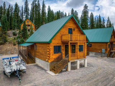 Cozy wooden cabin nestled in a forest clearing with a green roof.
